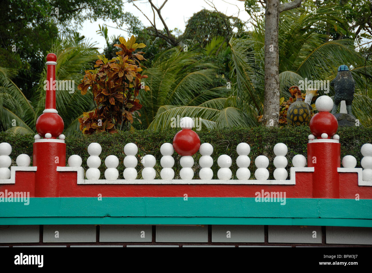 Mur rouge et turquoise insolite ou décoratif avec boules blanches au parc à thème chinois Tiger Balm Gardens, Singapour Banque D'Images
