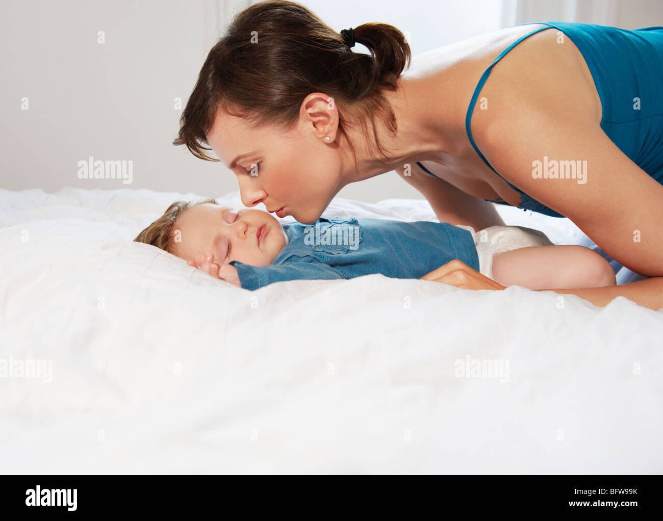 Mère embrassant bébé endormi Banque D'Images