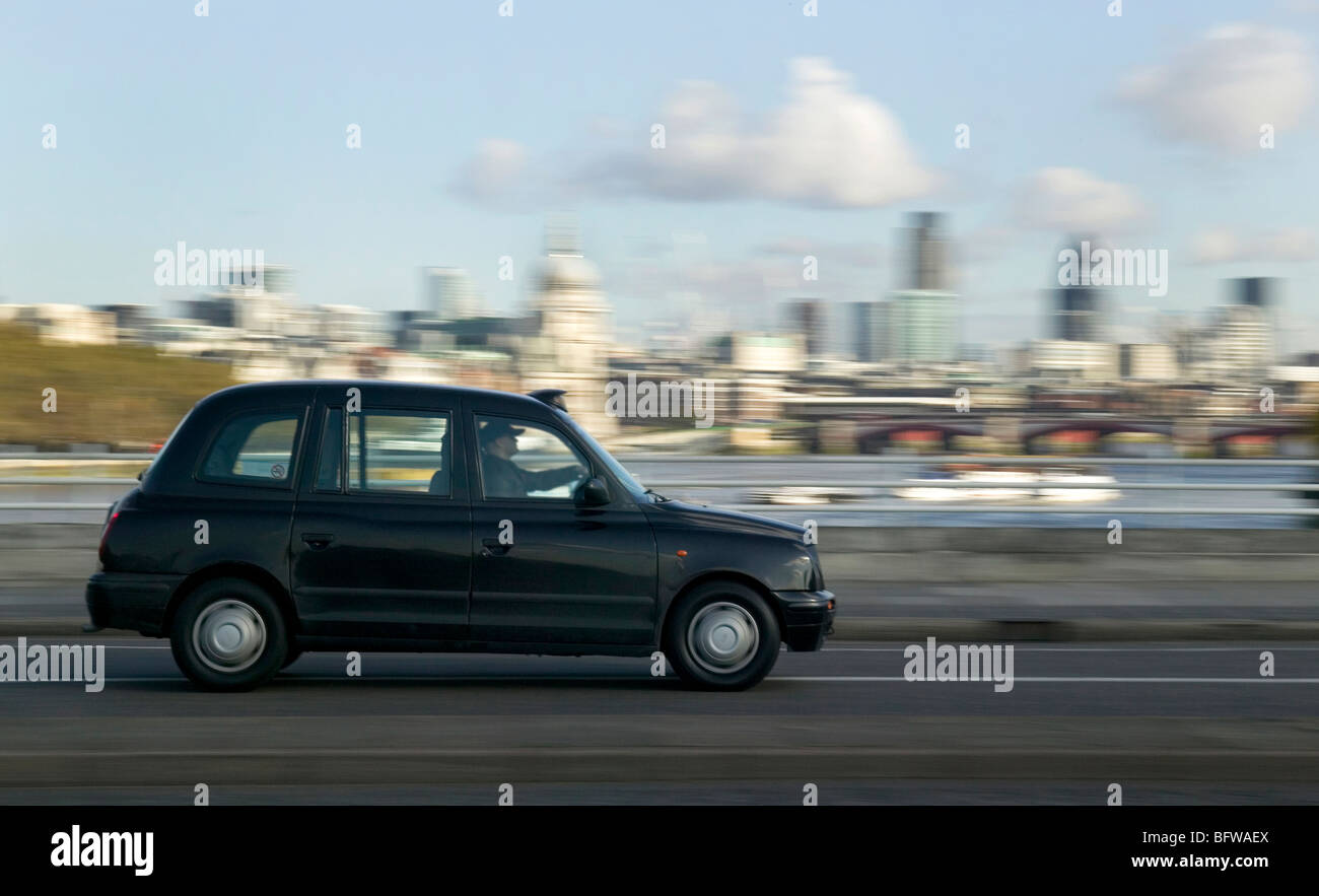 London Taxi conduite sur Waterloo Bridge avec City de Londres en arrière-plan. Banque D'Images