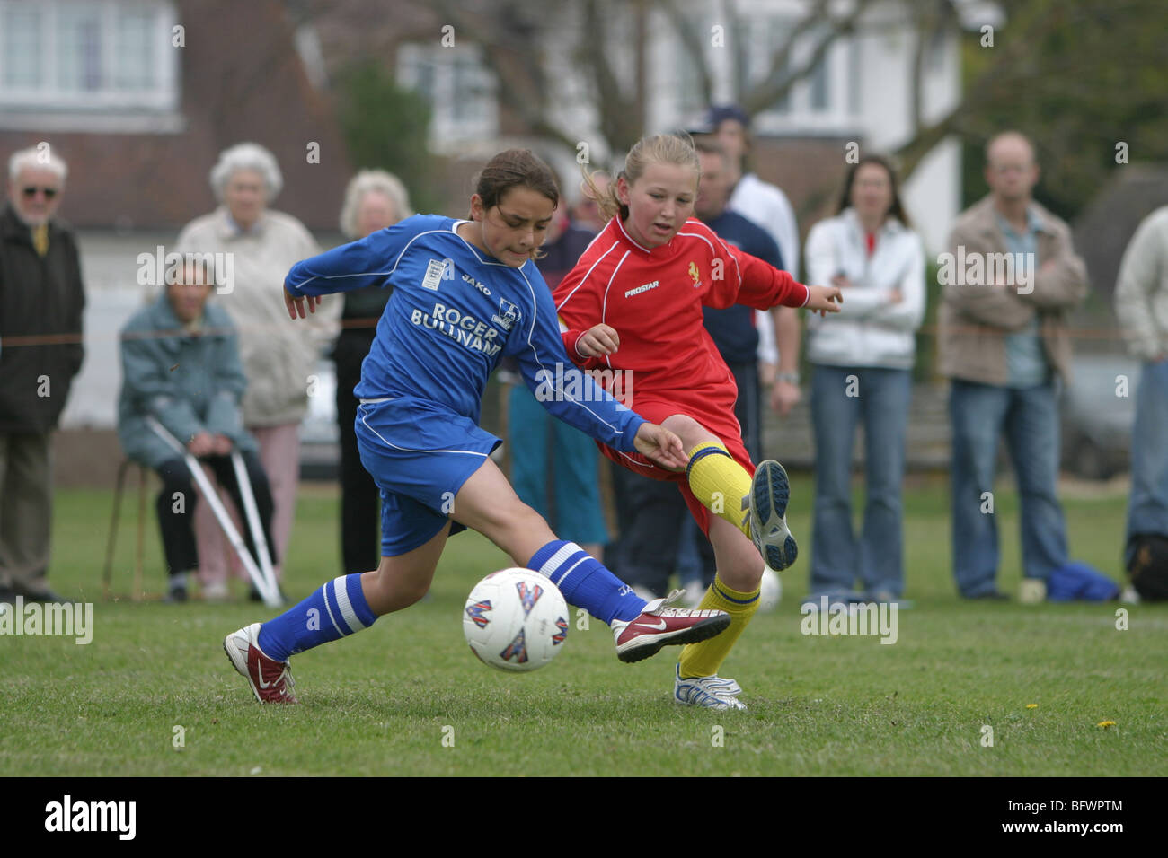 La jeune fille jouant au football dans un match de la ligue junior Banque D'Images