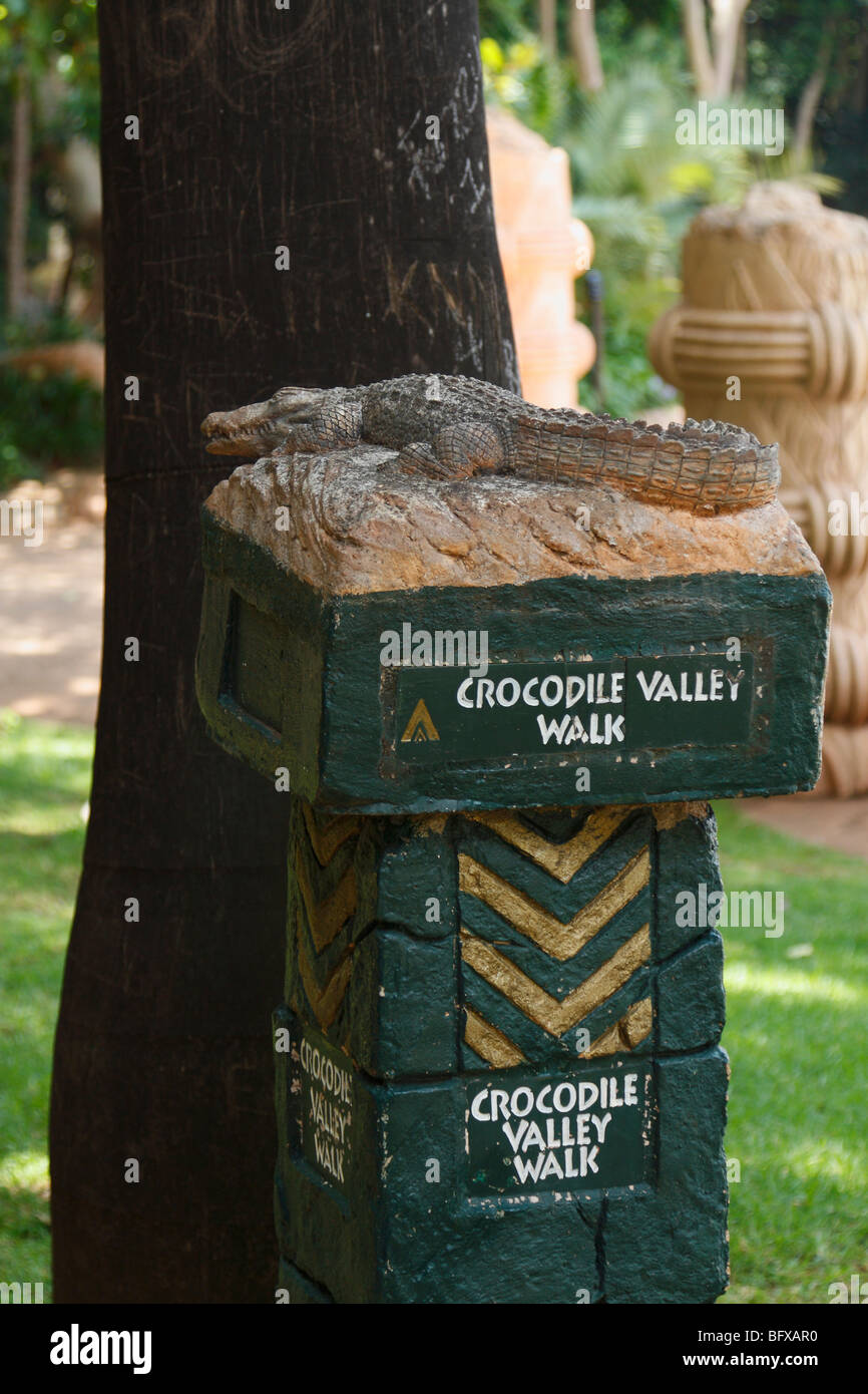 Vallée de crocodile à pied. panneau de signe et d'une petite sculpture de crocodile. Palace Hotel, Sun City, Afrique du Sud, Novembre 2009 Banque D'Images
