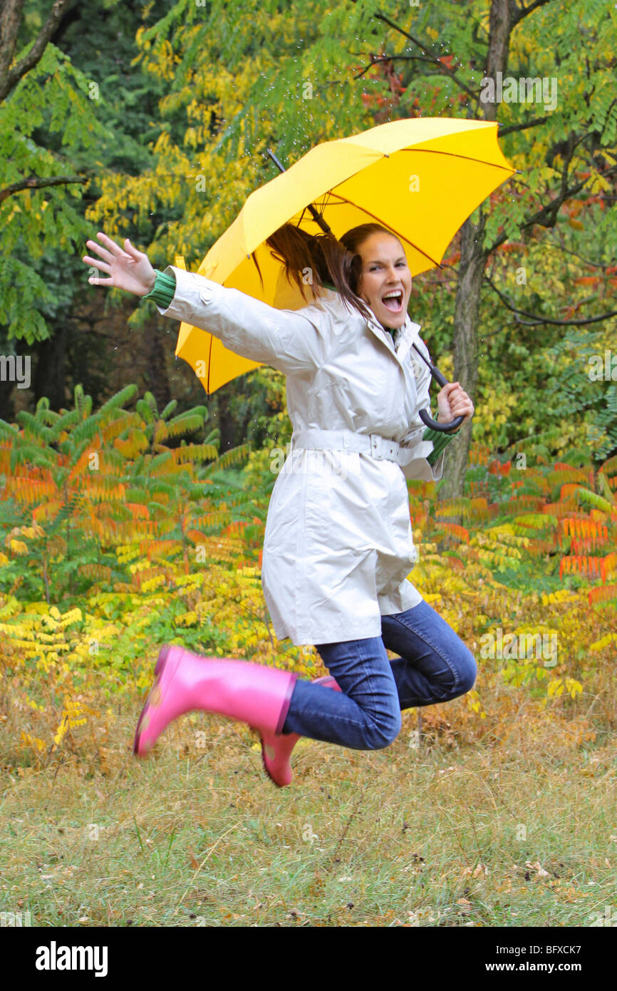 Frau mit Regenschirm im Herbst, femme avec parapluie ouvert jumping Banque D'Images