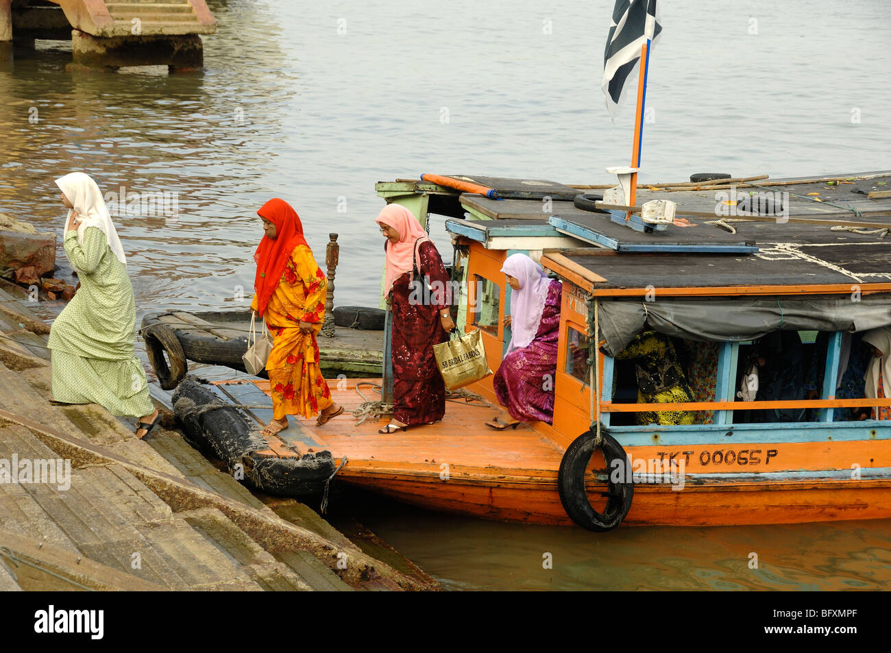 Les femmes musulmanes malais ou malaisiennes en robe islamique quittent un ferry sur le front de mer de Kuala Terengganu, en Malaisie Banque D'Images