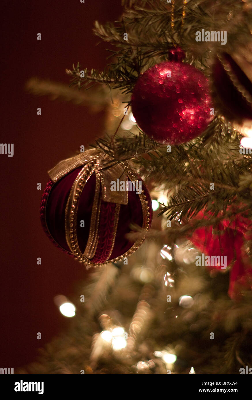 Boules rouges accroché sur un arbre de Noël à l'intérieur Banque D'Images