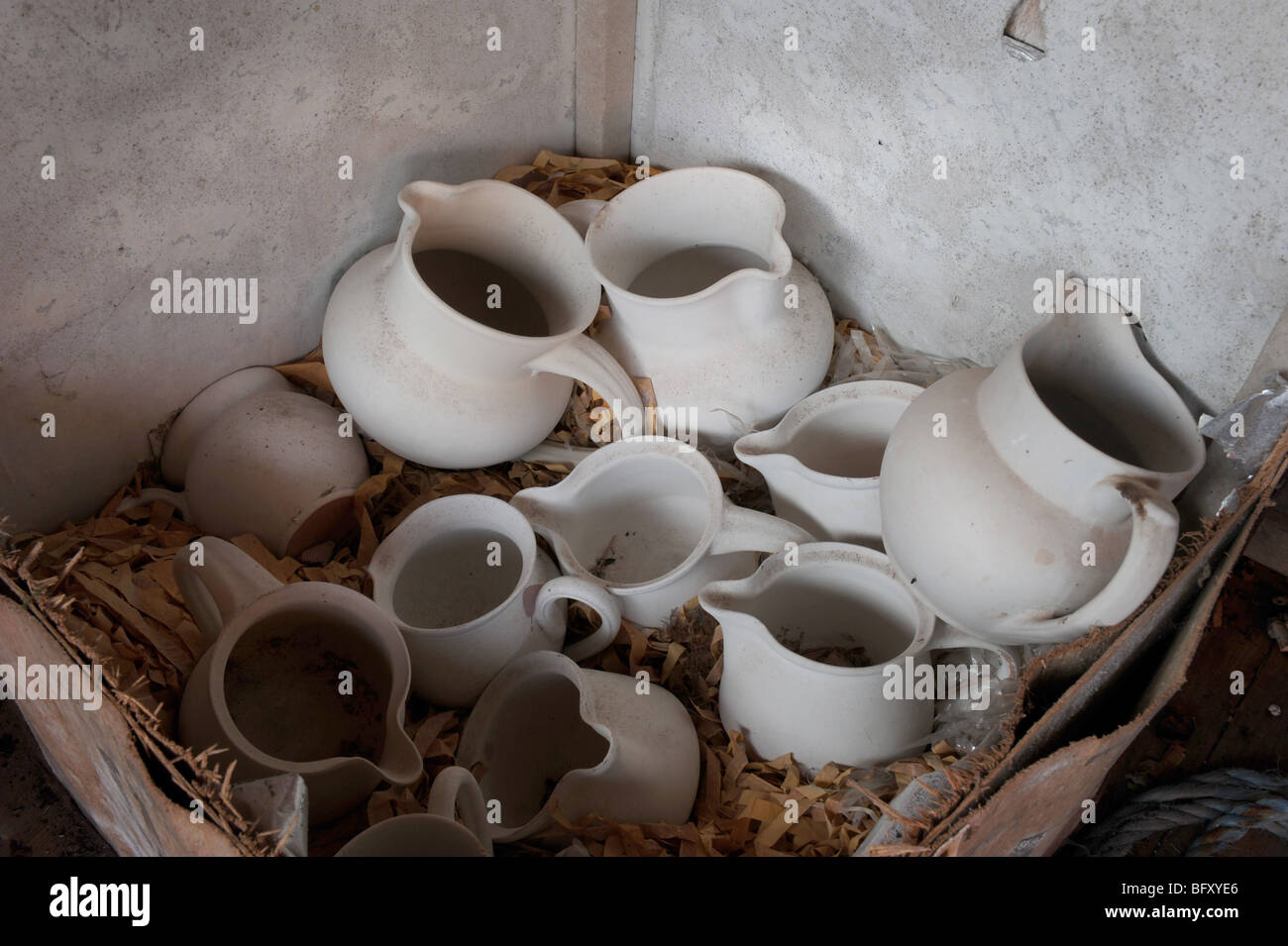 Cruches de lait en pot non émaillées dans un ancien coffre à thé abandonnés dans un studio de potiers Banque D'Images