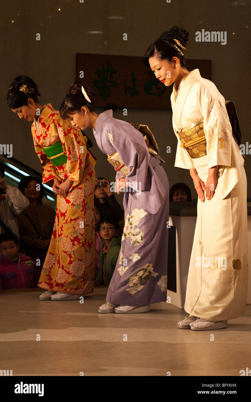 Les femmes japonaises s'inclinant à afficher au Kimono Textiles Nishijin Banque D'Images