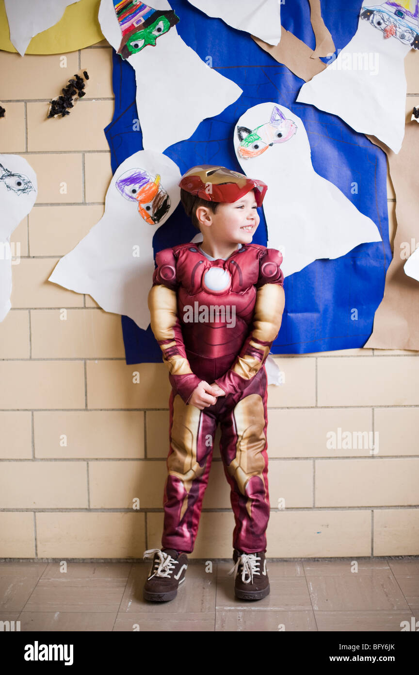 Un garçon de quatre ans habillée en homme de fer de Marvel Comics s'élève face à un mur d'Halloween à l'âge préscolaire Banque D'Images