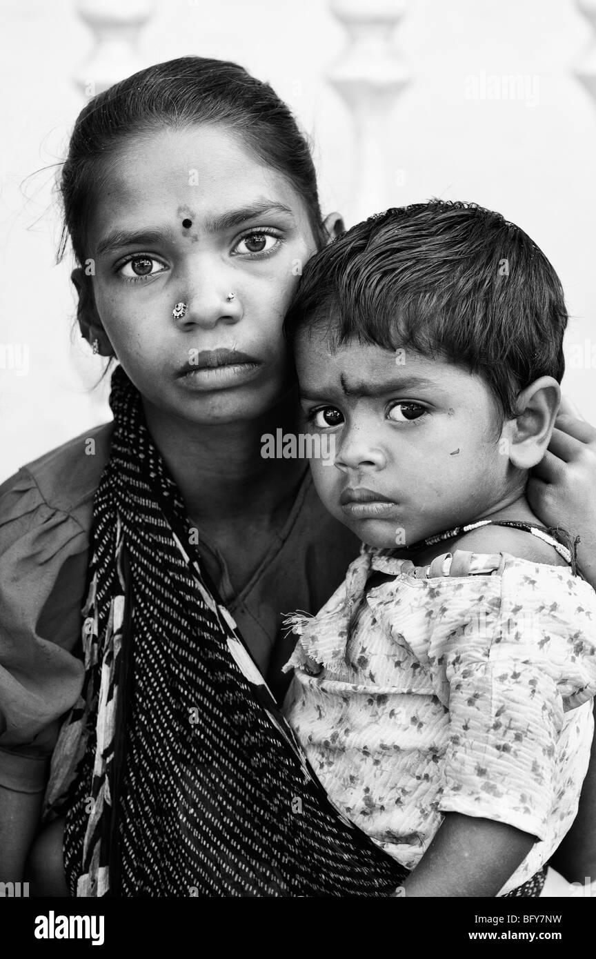 Pauvre fille indienne, berçant sa petite sœur dans une écharpe noire et  blanche Photo Stock - Alamy