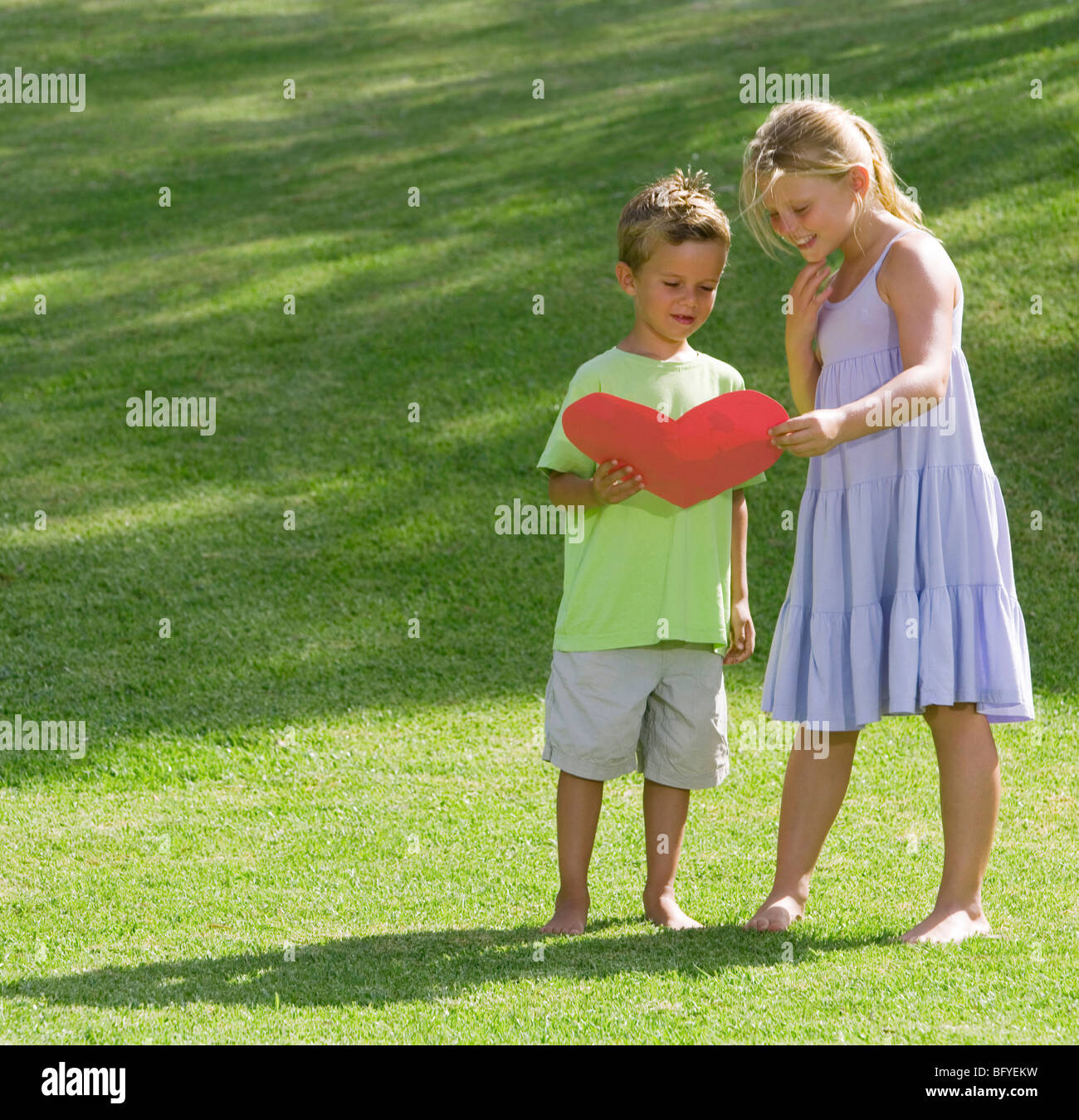 Fille et garçon tenant un cœur de papier Banque D'Images