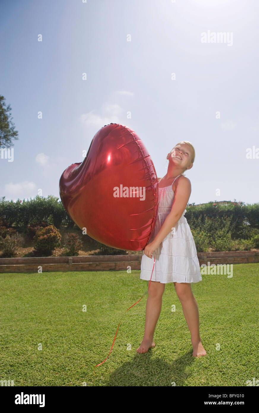 Young Girl holding big red heart balloon Banque D'Images