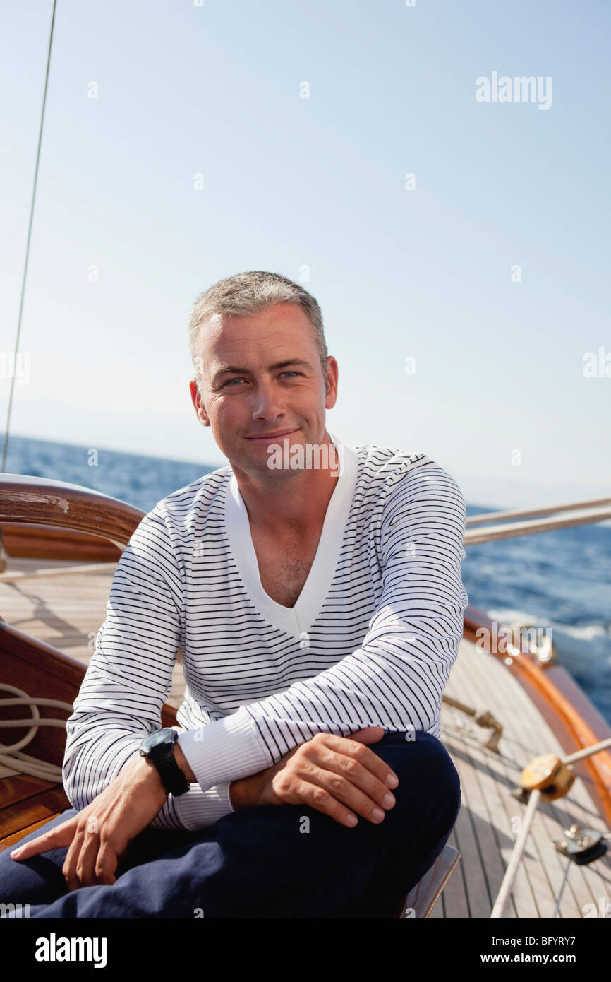 Man smiling sitting on deck Banque D'Images
