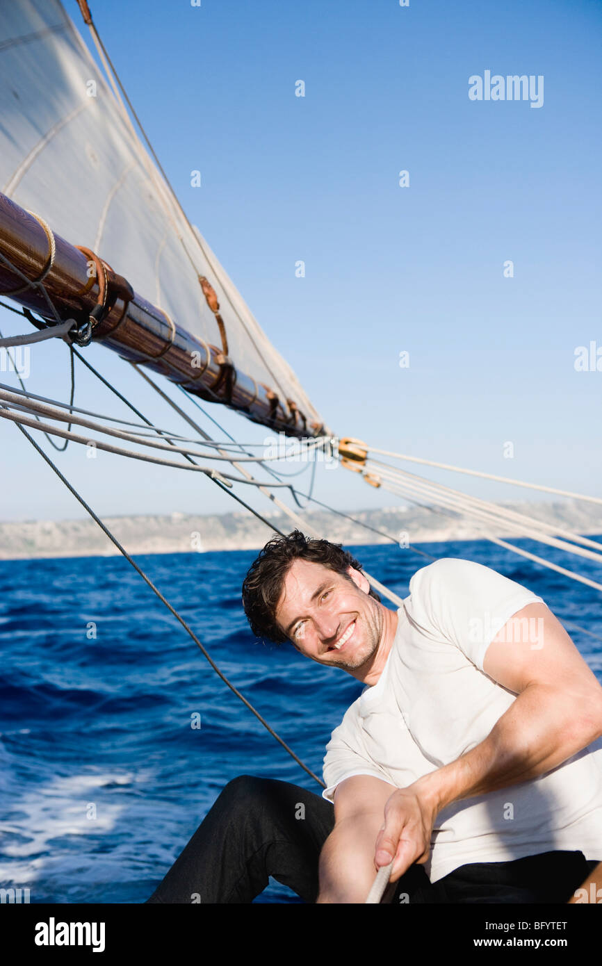 Man smiling diriger un bateau à voile Banque D'Images