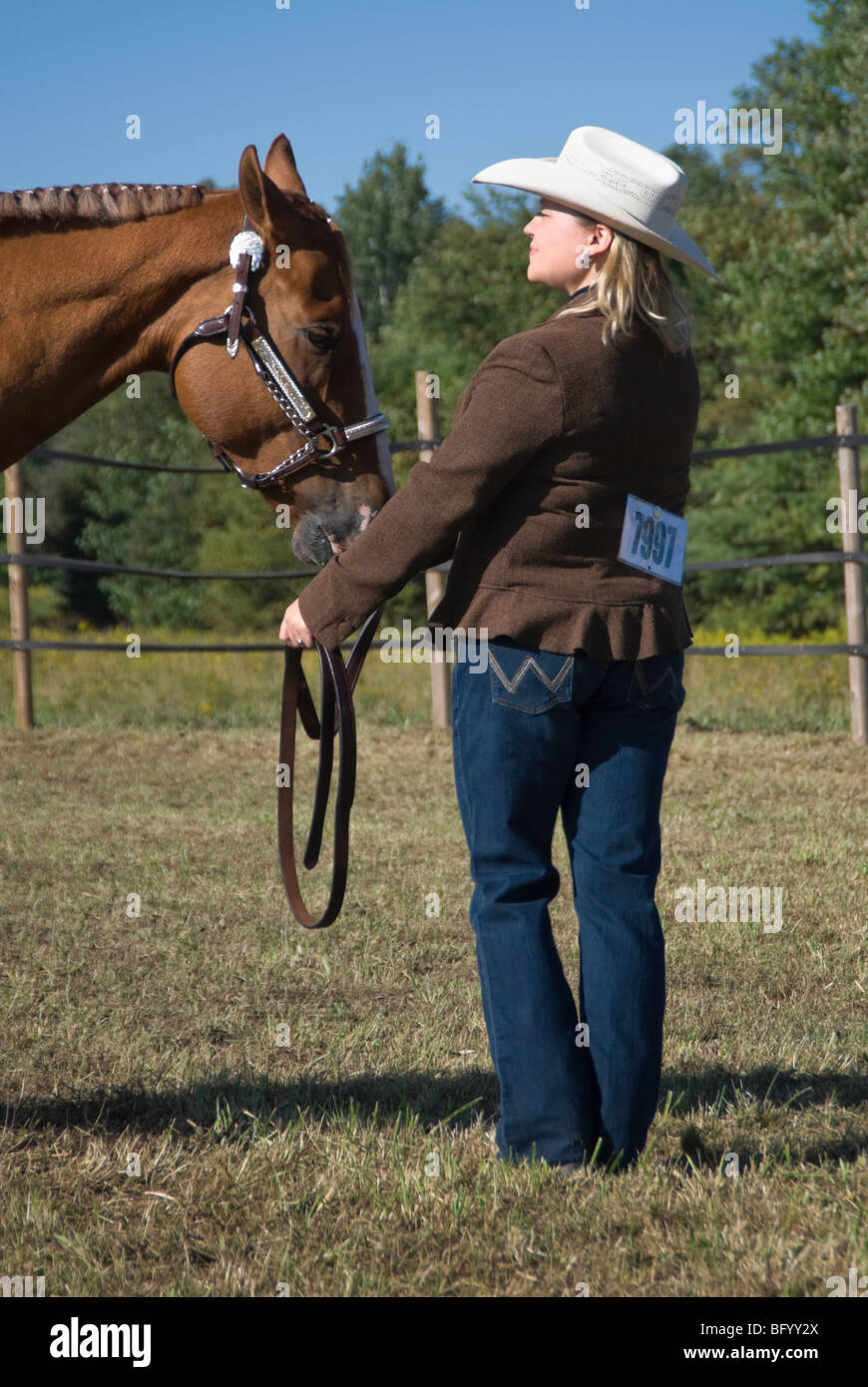 Très jolie jeune femme en compétition dans un petit cours dans un petit pays horse show. Banque D'Images