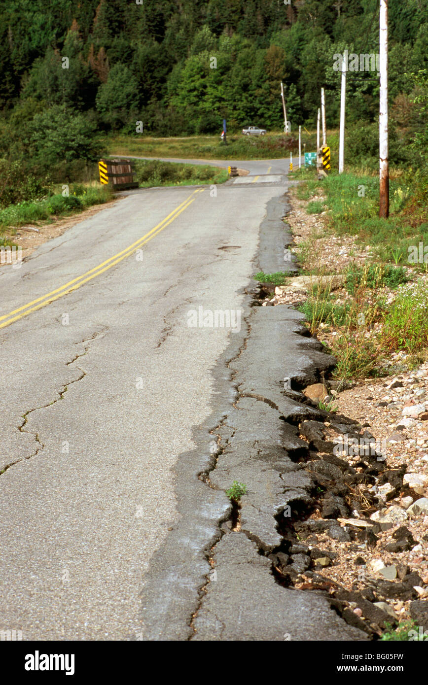 Les conditions routières dangereuses - l'érosion le long du côté de la route d'asphalte fissuré et cassé trottoir crée Banque D'Images