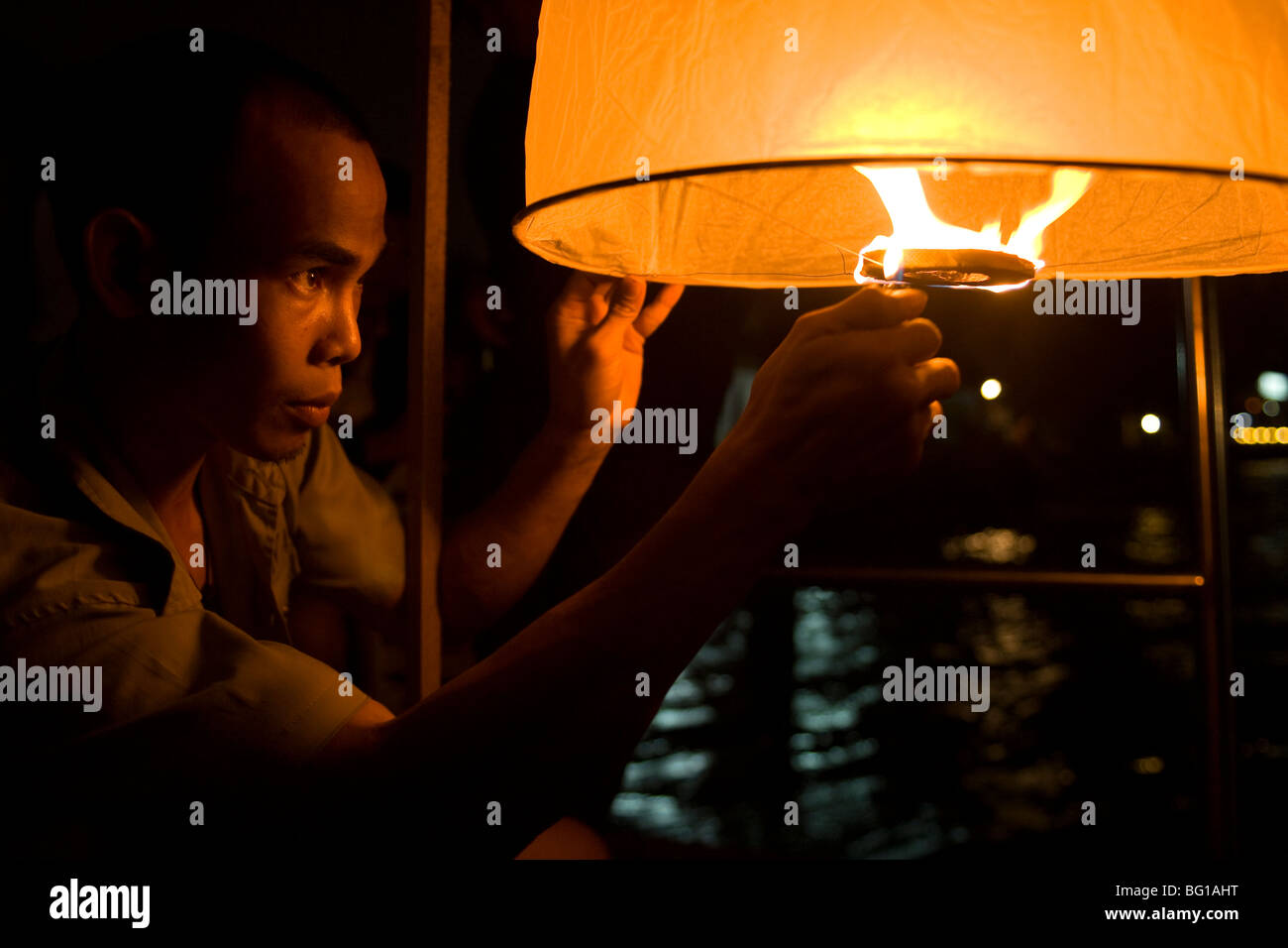 Thai man une lanterne d'éclairage pendant le festival de Loy Krathong thaï Banque D'Images
