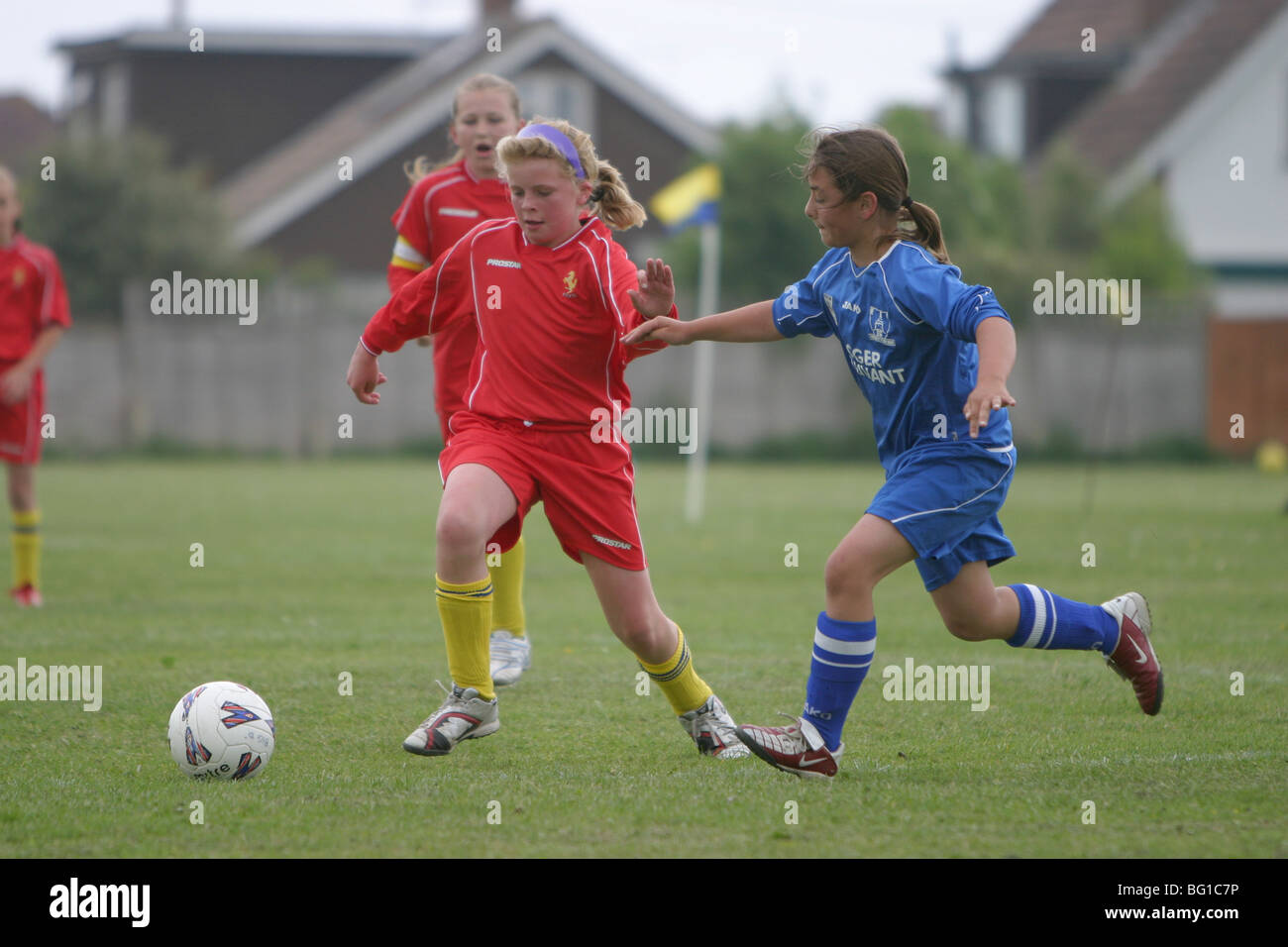 La jeune fille jouant au football dans un match de la ligue junior Banque D'Images
