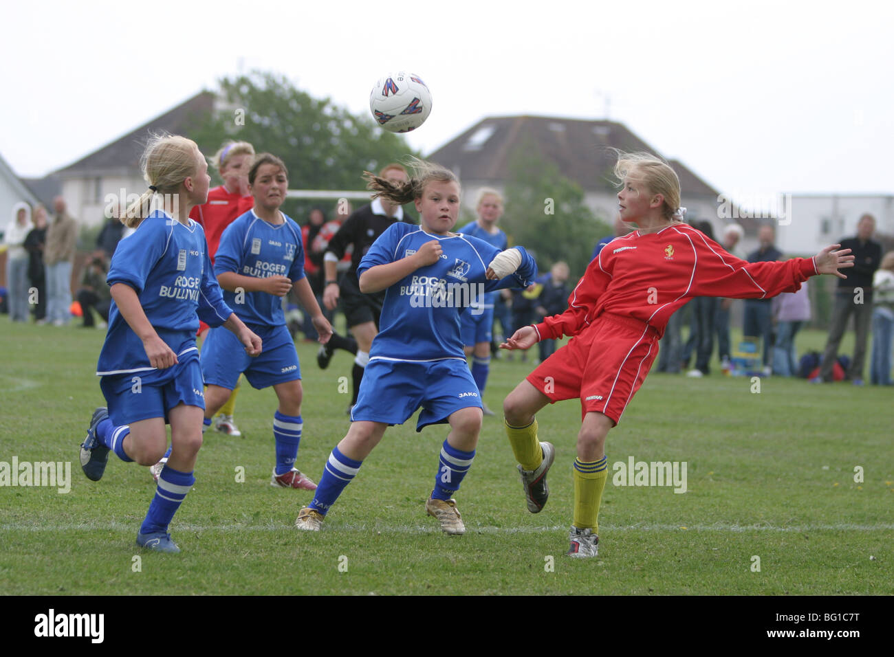 La jeune fille jouant au football dans un match de la ligue junior Banque D'Images