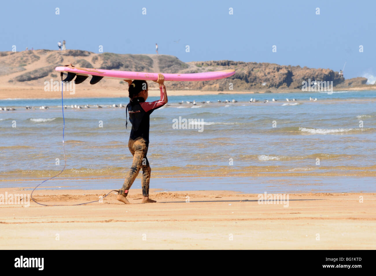 Jeune fille chefs pour le surf, Oualidia, Maroc Banque D'Images