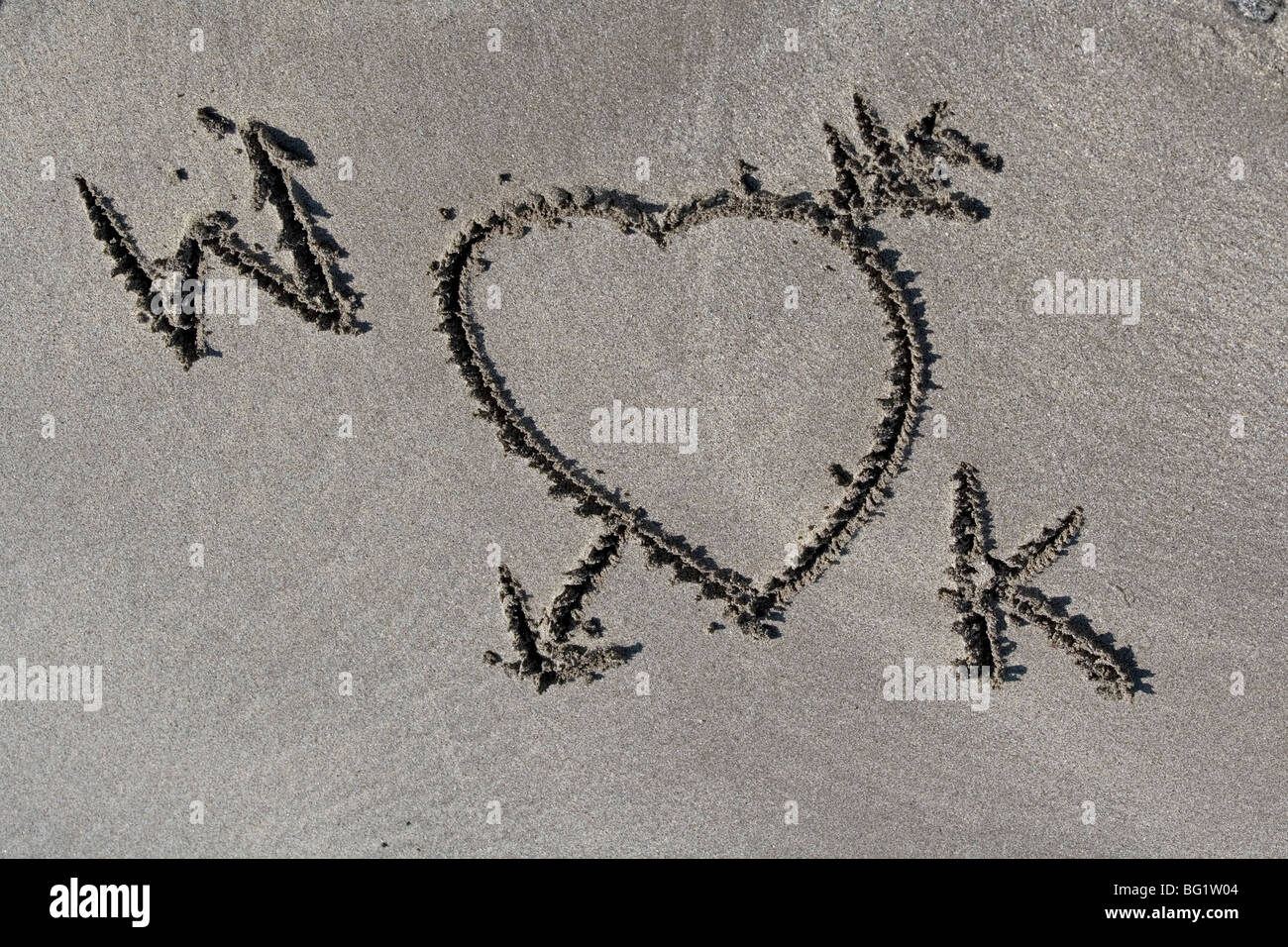 W et K , le Prince William et Kate Middleton. Wills et Kate. Une romance royale et le mariage. L'amour des lettres dans le sable. Banque D'Images