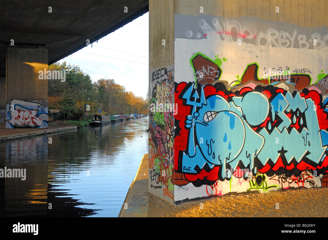 Graffitis colorés sur le mur par canal Surrey England Banque D'Images