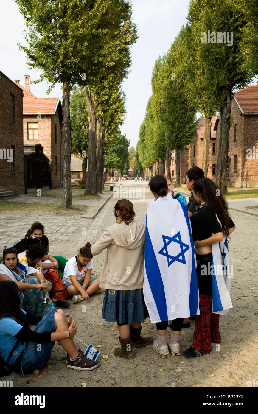 L'école juive / collège enfants / étudiants : groupe sur une tournée de camp nazi d'Auschwitz. La Pologne. Les filles portent des drapeaux israéliens. Banque D'Images