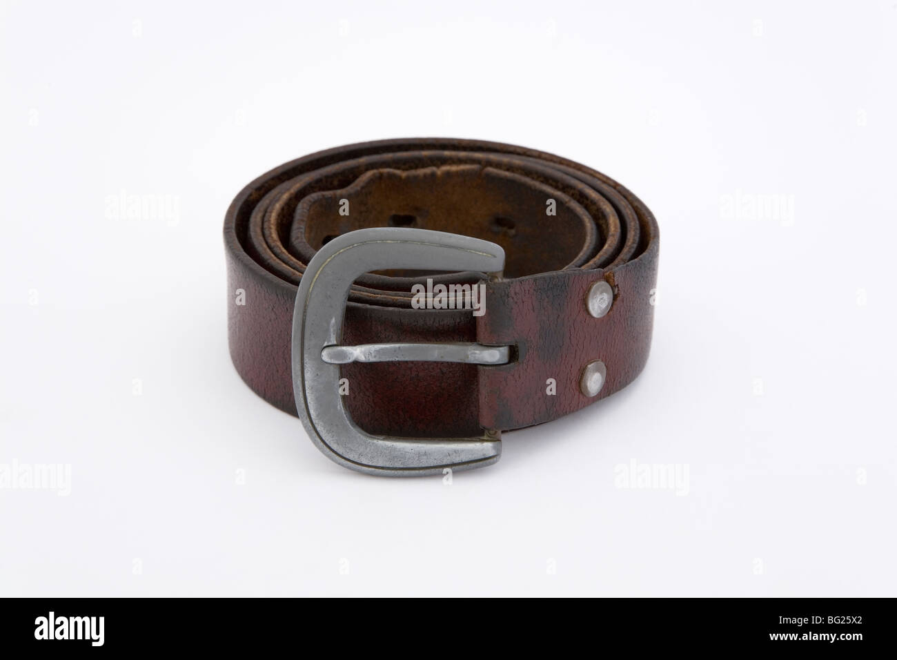 Un vieil homme ceinture en cuir marron sur fond blanc usé utilisé gondolé enroulés serrés doublé tissu accessoires stylos vêtements tenir Banque D'Images