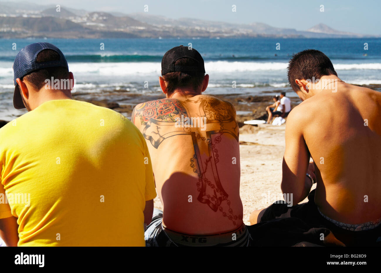 L'homme tatoué sur le dos avec la compétition de surf en Espagne regarder Banque D'Images
