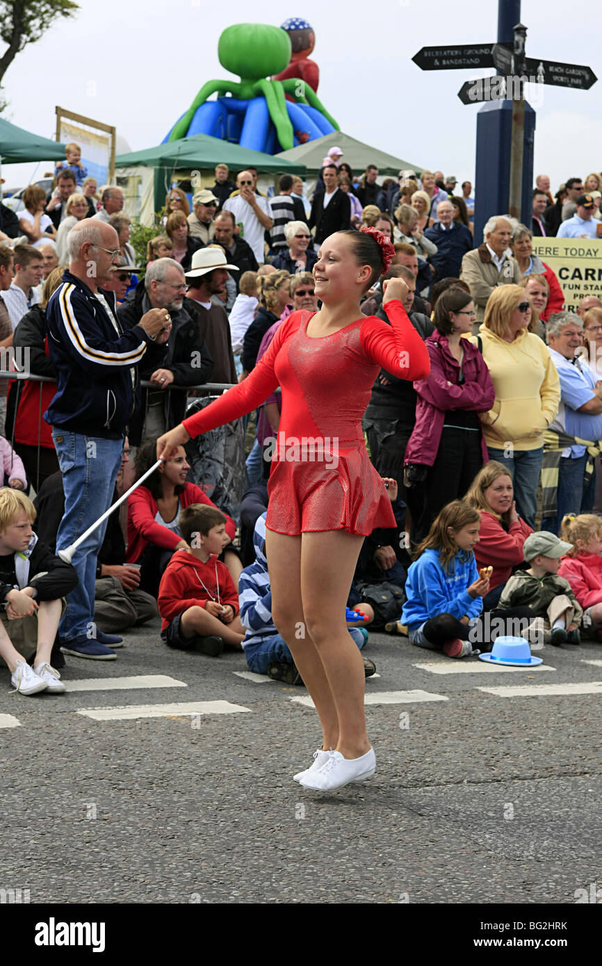 Adolescente son tourbillonnant matraques dans un défilé de majorette en Angleterre Banque D'Images