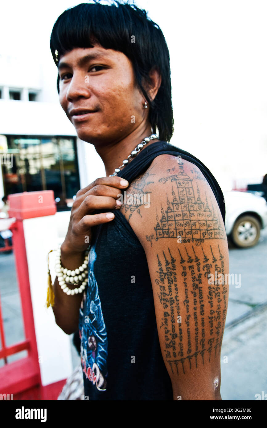 Un homme Thaï bouddhiste montre ses tatouages sur son bras. Banque D'Images