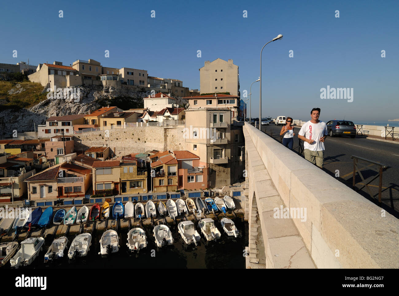 Bateaux et maisons de pêche dans le port de Vallon des Auffes Inlet, Pont sur la Corniche, et joggeurs, Marseille ou Marseille, Provence, France Banque D'Images