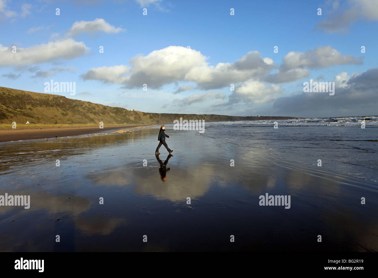 Lone walker sur une belle plage de sable de St Cyrus, Aberdeenshire, Scotland, UK Banque D'Images
