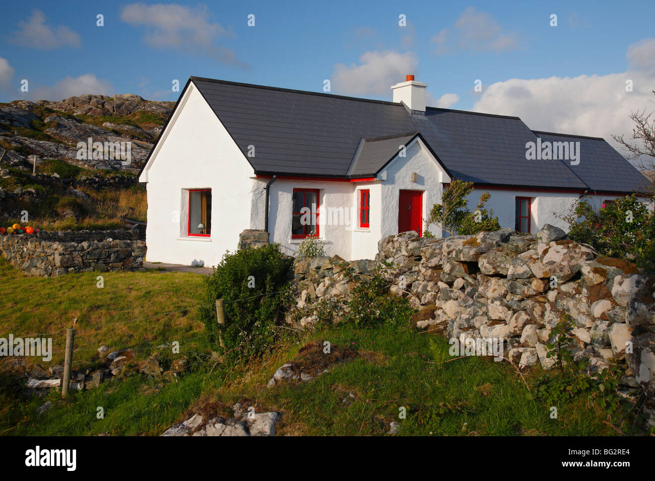 Chalet d'été traditionnel irlandais rouge avec porte et fenêtres de Ballyconneely près de Roundstone, Connemara, Irlande Banque D'Images