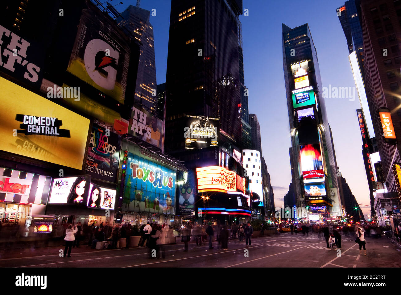 Scène de nuit de Times Square à Manhattan (New York City) avec tous les allume les panneaux et publicités, et de nombreux touristes. Banque D'Images