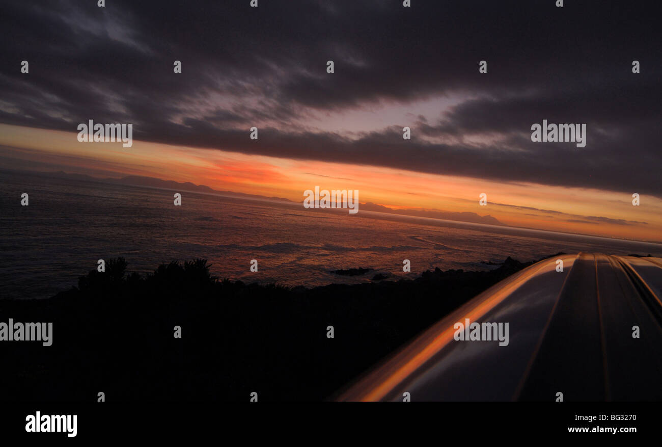 Le coucher du soleil et nuages de tempête sur la péninsule du Cap et de False Bay à réfléchir sur le haut. Banque D'Images