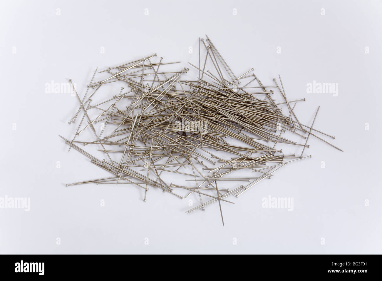 Pile d'aiguilles sur fond blanc articles en métal sharp double bande pincée groupe nombre quantité boîte métallique ustensile maison point Banque D'Images