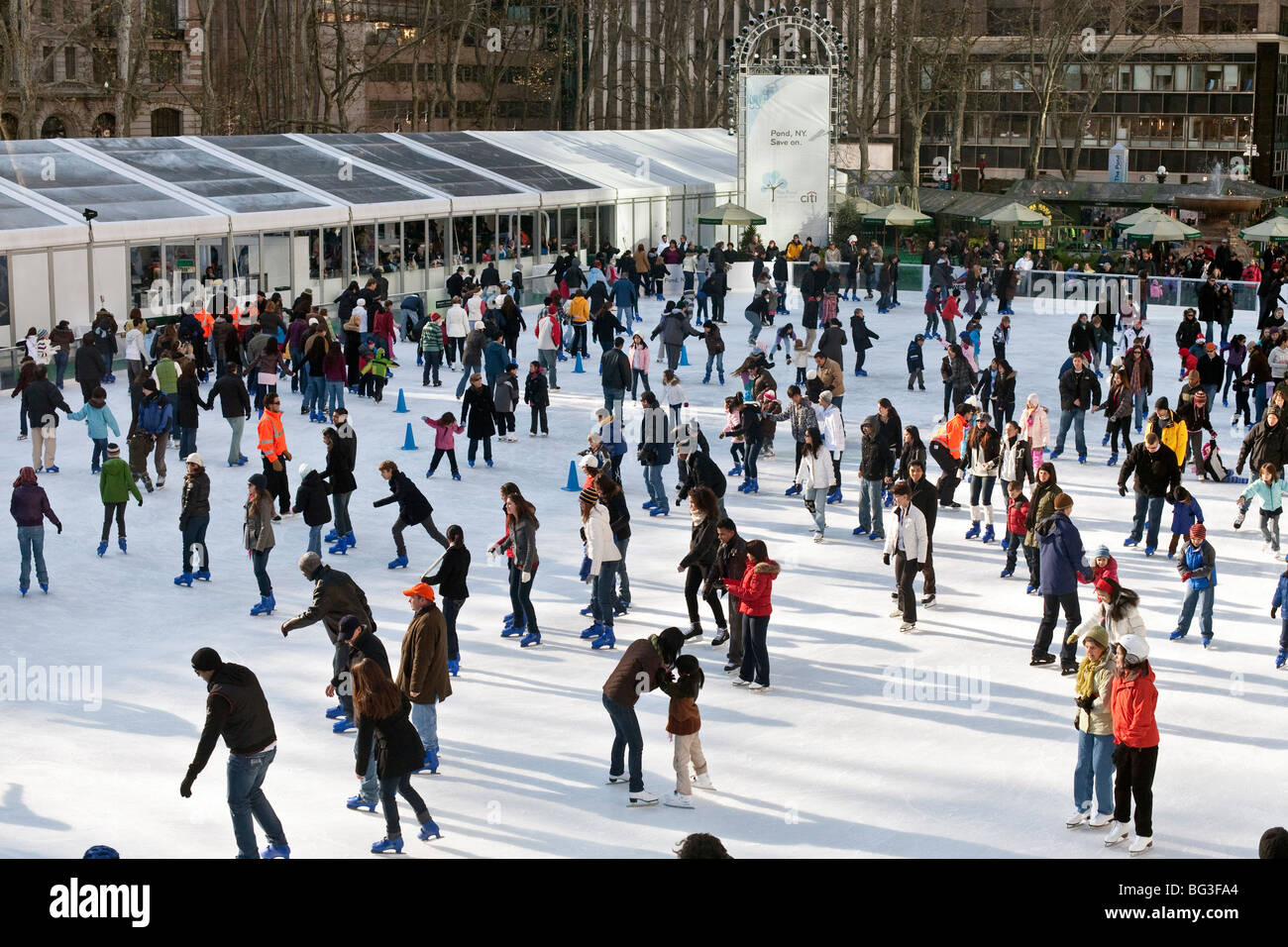 Heureux de foule multiculturelle dimanche les patineurs ont l'amusement sur la glace de l'étang de patinage libre de Bryant Park à Manhattan, New York City Banque D'Images
