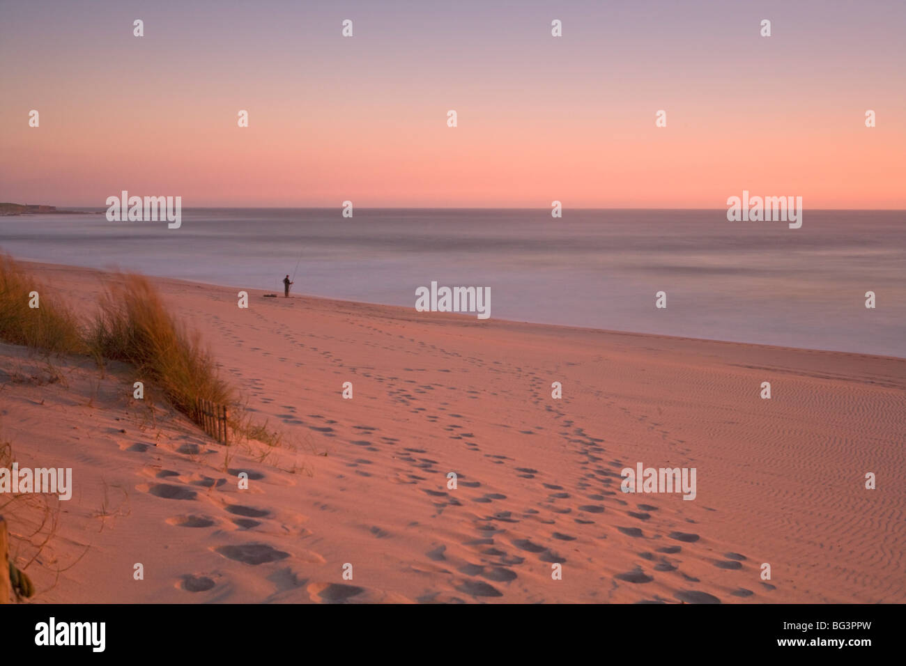 Pêcheur solitaire sur la plage au coucher du soleil, le Portugal, l'Europe Banque D'Images