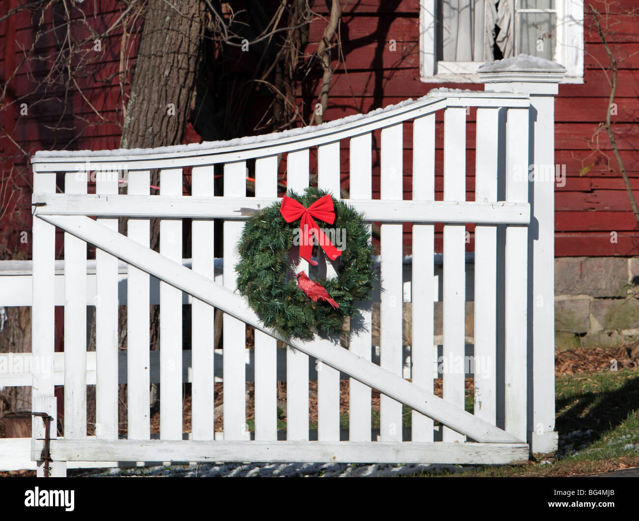 Une couronne de Noël avec un arc rouge et un cardinal rouge sur un grand  portail blanc. Une image très maison de vacances Photo Stock - Alamy