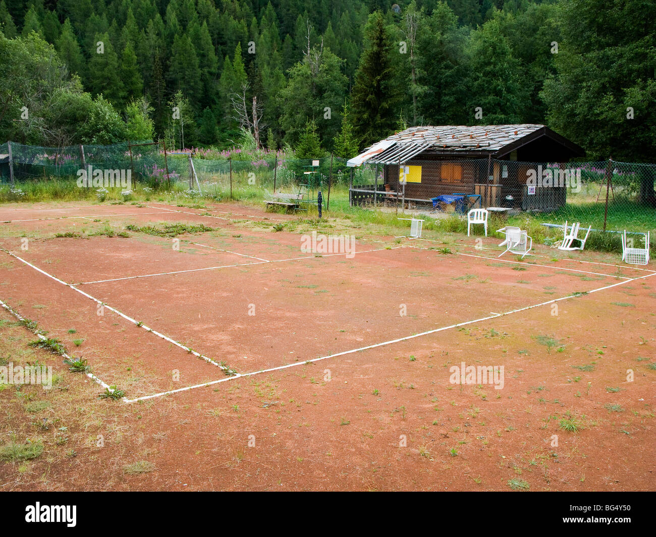 Abandon tennis vieux abandonnés négligé ligne interrompue lignes terre rouge les mauvaises herbes sports Val D'Aoste Italie Alpes Ayas Banque D'Images