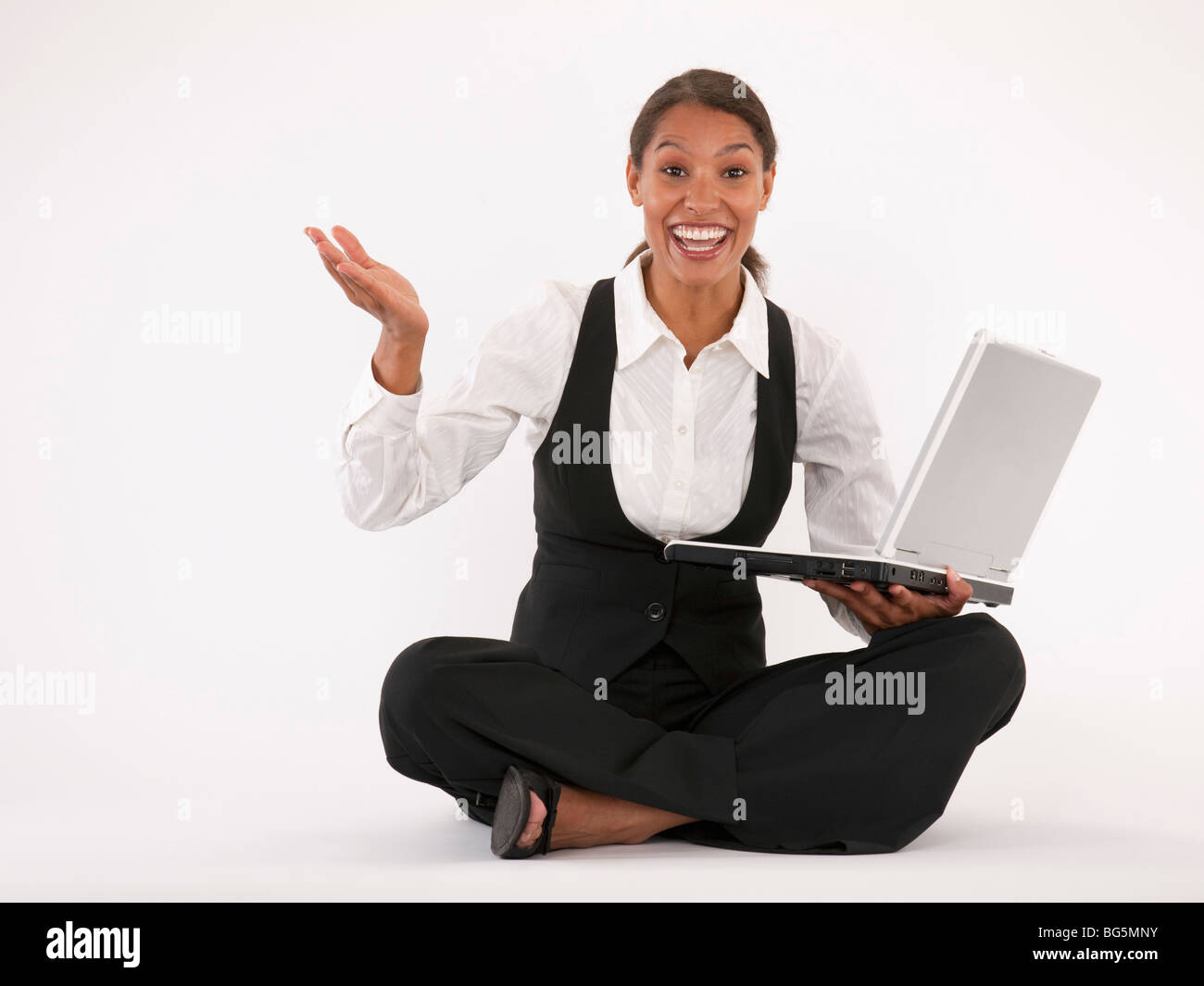 Jeune femme assise sur le sol à l'aide d'ordinateur portable. Format horizontal. Banque D'Images