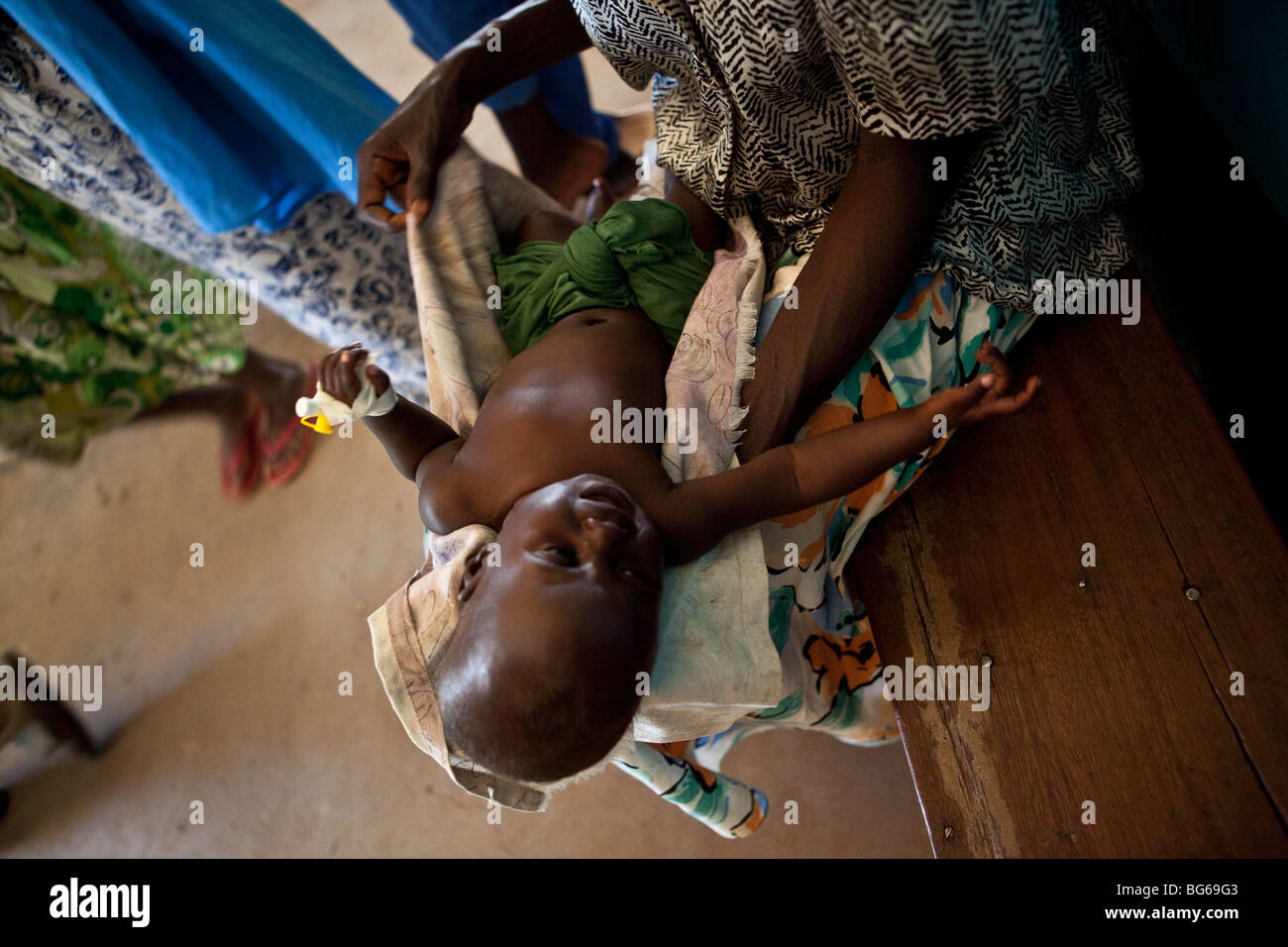 Une mère tient son jeune enfant dans un hôpital d'Amuria, en Ouganda. Banque D'Images