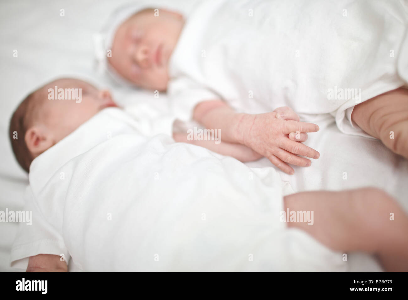 Les jumeaux bébé dormir tout en se tenant la main Photo Stock - Alamy