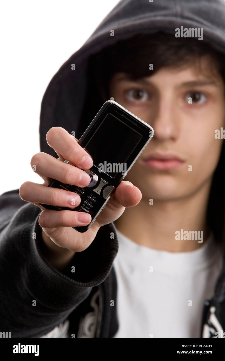 Close-up portrait of young man wearing hooded sweatshirt montrant téléphone mobile. L'accent sur le téléphone Banque D'Images