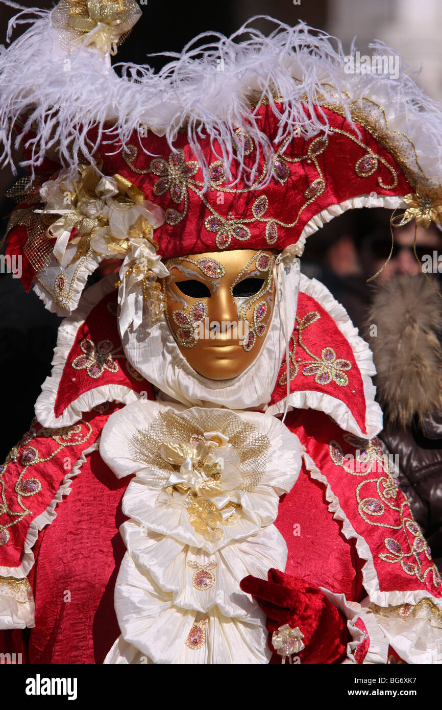 Close-up of a Venetian homme ou femme portant un masque d'or et rouge et blanc costume brodé à Venise le Carnaval 2009 Banque D'Images