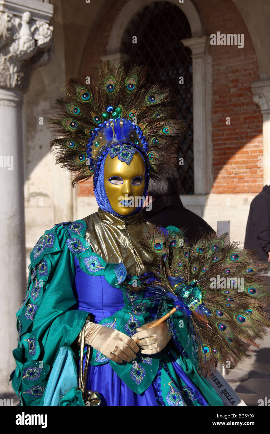 Close-up d'une femme vénitienne portant un masque d'or et d'un costume bleu  et vert décoré de plumes de paon, Carnaval de Venise Photo Stock - Alamy