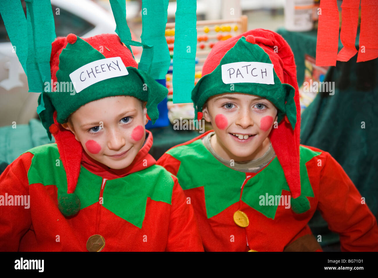 Les jeunes garçons en rouge et vert en elfe de Noël à l'extérieur de l'atelier Festival d'hiver de l''Usk Usk Monmouthshire South Wales UK Banque D'Images