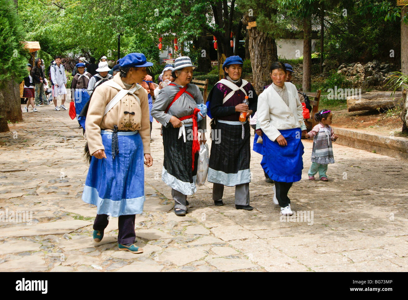 Les femmes Naxi walking in park, Lijiang, Yunnan, Chine Banque D'Images