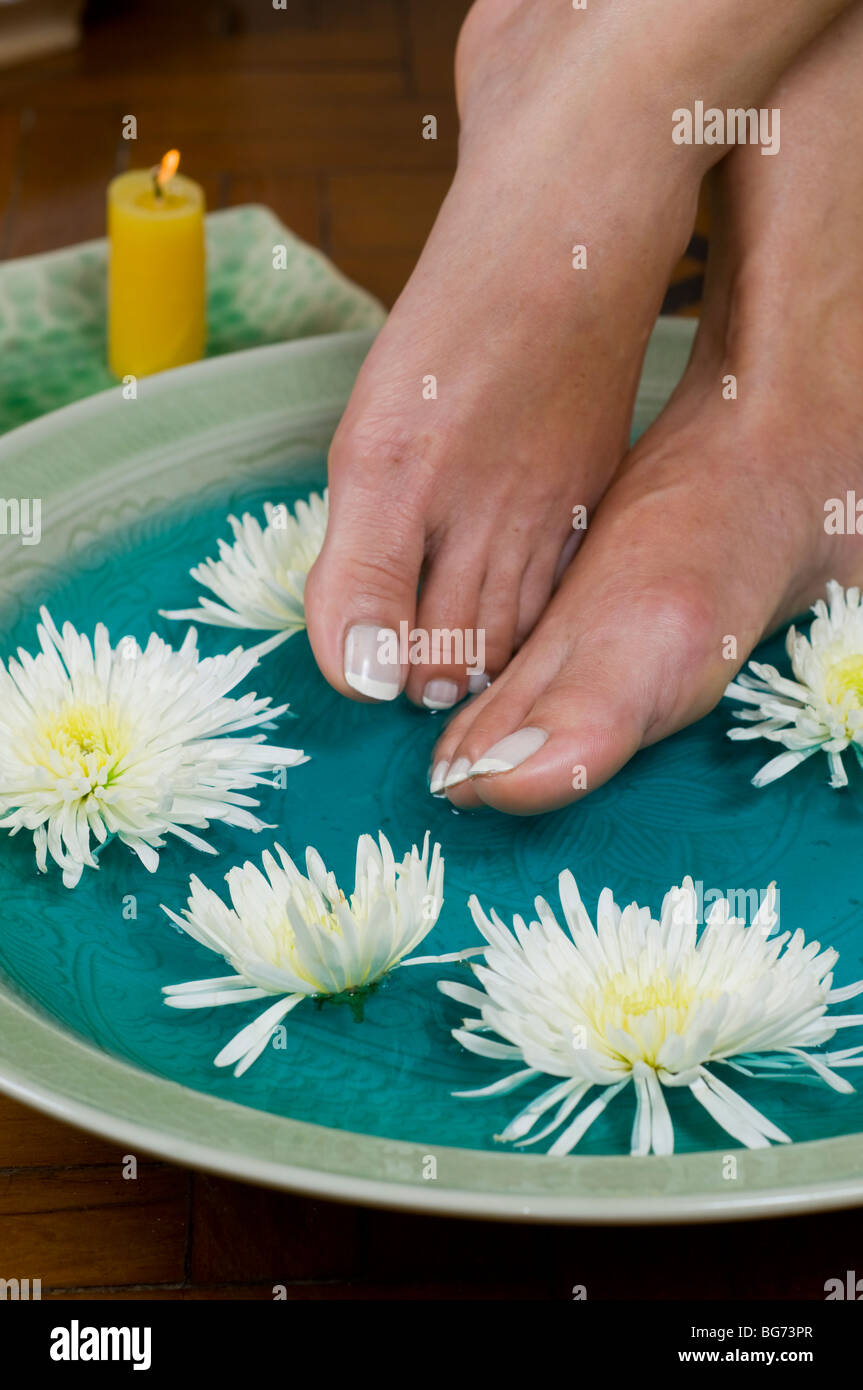 Pieds profitez d'un bain de pied relaxant aux huiles parfumées à day spa Banque D'Images
