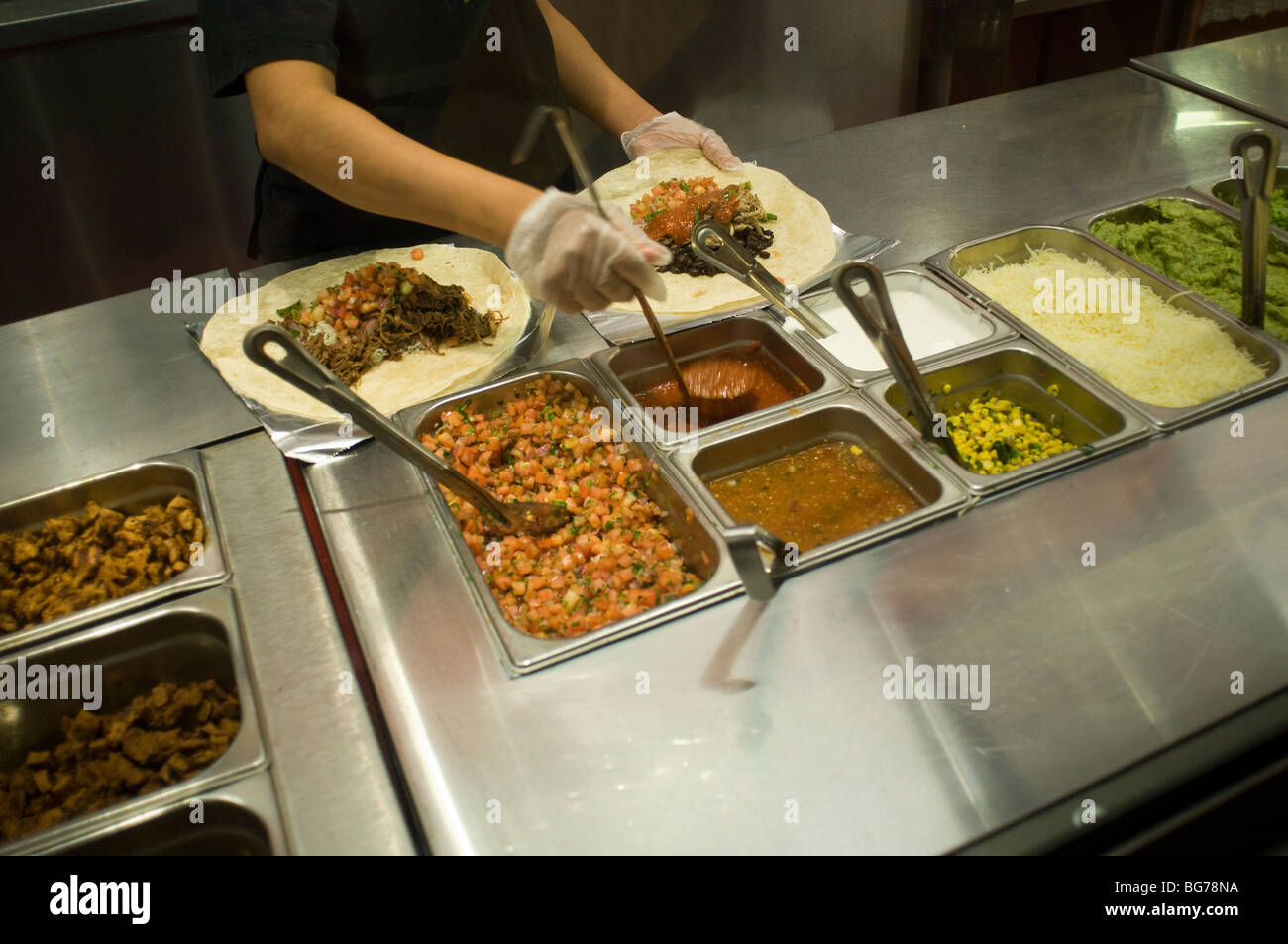 Préparer les travailleurs à un burritos Chipotle Mexican Grill dans Midtown à New York Banque D'Images