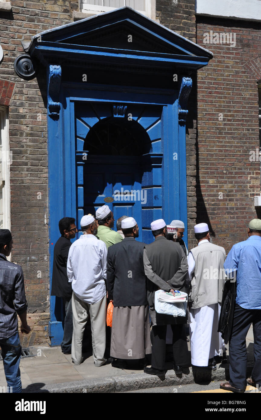 Les hommes d'attendre à l'extérieur en brique mosquée Land East London UK Banque D'Images